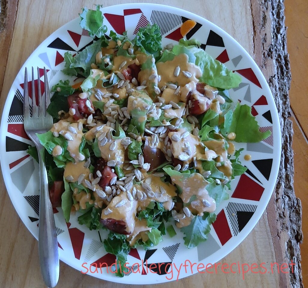 Salad on a plate with a fork on top of a wooden board.